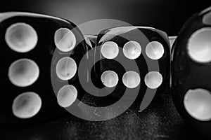 Group of playing dice cubes on black surface, macro