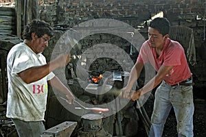 Group portrait of blacksmiths at work in smithy