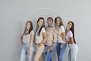 Group portrait of cheerful beautiful diverse young ladies standing together in studio