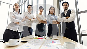 Group portrait of five diverse businessmen, two men and three women at meeting desk. They hold and catch other`s hands. Idea for