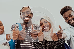 Group portrait of happy African students standing together against a white background and showing ok sign thumbs up