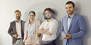 Group portrait of happy confident business people standing against studio background