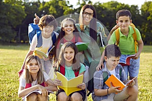 Group portrait of happy school children together with their teacher during fun class outside