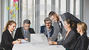 Group portrait of six business people team sitting and talking in conference together in an office with intimate and unity manner