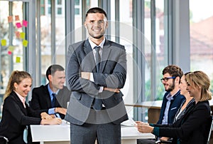 Group portrait of six business people team sitting and talking in conference together in an office and while the man boss stand