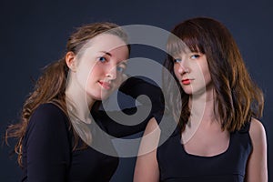 Group portrait of two girls on a dark background