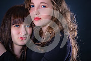 Group portrait of two girls on a dark background