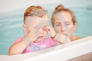 Group portrait of white Caucasian mother and child daughter playing in water diving in swimming pool