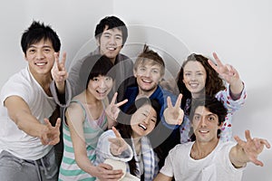 Group portrait of young friends showing peace sign