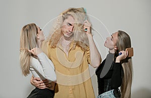 Group portrait of young people combing hair. Attractive cheerful sexy, fashionable group models combing hair