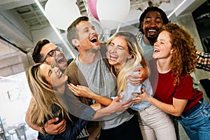 Group portrait of young startup business team celebrating success in the office