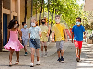 Group of positive children in masks walking together