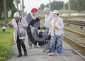 Group of positive  seniors people waiting train before traveling during a pandemic