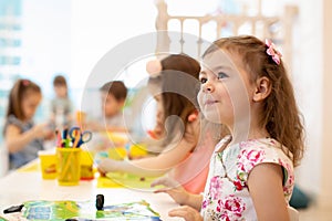 Group of preschool children engaged in drawing and crafts photo