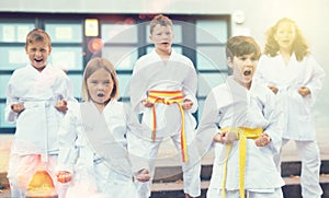 Group of preteen children learning karate movements in schoolyard