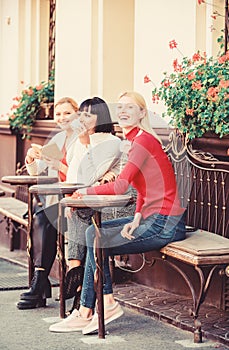 Group pretty women terrace entertain themselves with reading and listening. Coffee cafe. Way to relax and recharge