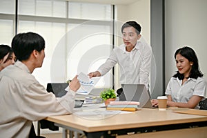 A group of professional Asian businesspeople or financial workers is in the meeting