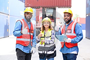 Group of Professional Engineers and foreman container cargo standing in shipping container yard look at the camera and show thumbs