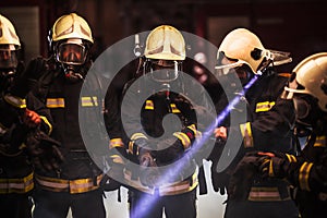 Group of professional firefighters. Firemen wearing uniforms, protective helmets and oxygen masks. Smoke in the background