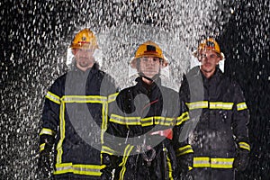 Grupo de profesionalmente bomberos de marcha través de lluvioso noche sobre el ahorrar misión ellos determinado 