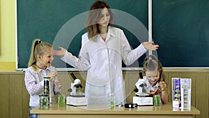 Group Of Pupils With Teacher Using Microscopes In Science Class. Back to school and home schooling