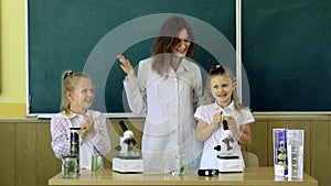 Group Of Pupils With Teacher Using Microscopes In Science Class. Back to school and home schooling