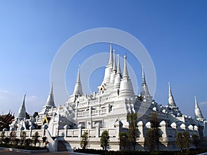 group of pure white pagoda at wat asokaram with clear bright blue sky