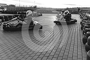 A group of racers on karts are approaching the finish line in an active battle for first place in the championship, sreet. extreme