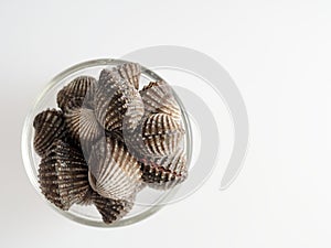 A group of raw cockle, ark shell, in a glass bowl isolated on white background