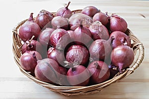 Group of red onions in a wicker basket.