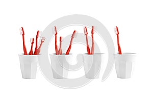 Group of red toothbrush in a plastic cup isolated on white background