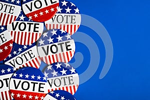 A group of red, white and blue VOTE button on a blue background