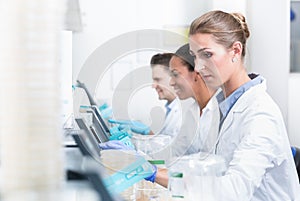 Group of researchers during work on devices in laboratory