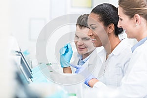 Group of researchers during work on devices in laboratory