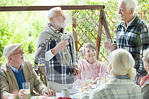 Group of retired friends having fun during birthday party at the garden