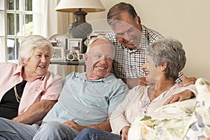 Group Of Retired Friends Sitting On Sofa At Home Together