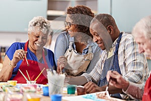 Group Of Retired Seniors Attending Art Class In Community Centre With Teacher photo