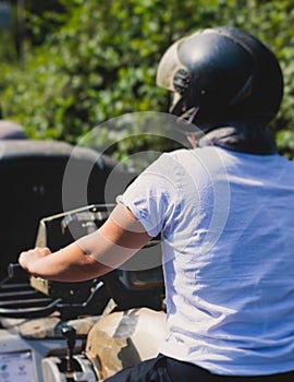 Group of riders riding ATV vehicle crossing forest rural road, process of driving rental vehicle, all terrain quad bike vehicle,