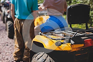 Group of riders riding ATV vehicle crossing forest rural road, process of driving rental vehicle, all terrain quad bike vehicle,