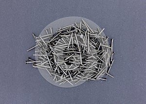 Group of ring shank underlayment nails on a dark paper background