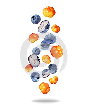 Group of ripe juicy blueberries and cloudberries close up in the air isolated on a white background