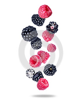 Group of ripe juicy raspberries and blackberries close up in the air isolated on a white background