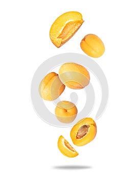 Group of ripe whole and sliced apricots close up in the air isolated on a white background