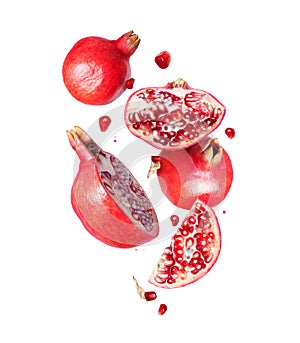 Group of ripe whole and sliced pomegranates in the air isolated on a white background