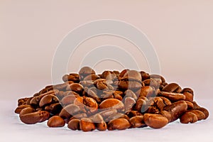 A group of roasted coffee beans, fresh brown in colour, ready to be grinded and made drinks