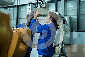 Group of Robotics engineers working with Programming and Manipulating Robot Hand, Industrial Robotics Design, High Tech Facility