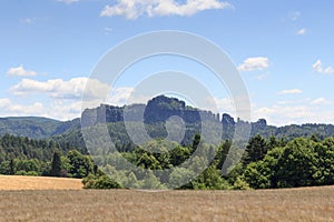 Group of rocks Schrammsteine and Falkenstein with grain field in Saxon Switzerland