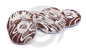 Group of round chocolate cookies drizzled with white icing