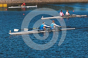 Group of rowing team female girl athletes sculling during competition, kayak boats race in a rowing canal, regatta in a summer