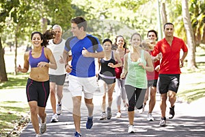 Group Of Runners Jogging Through Park photo